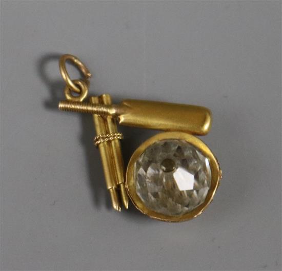 An early 20th century yellow metal stumps, cricket bat and paste cricket ball pendant, 25mm.